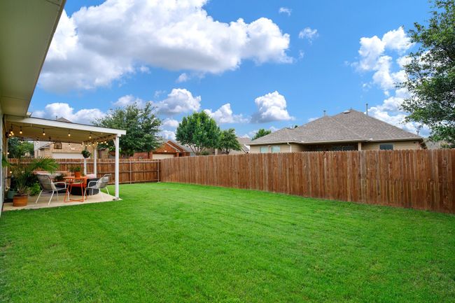Fenced backyard with a patio area | Image 24