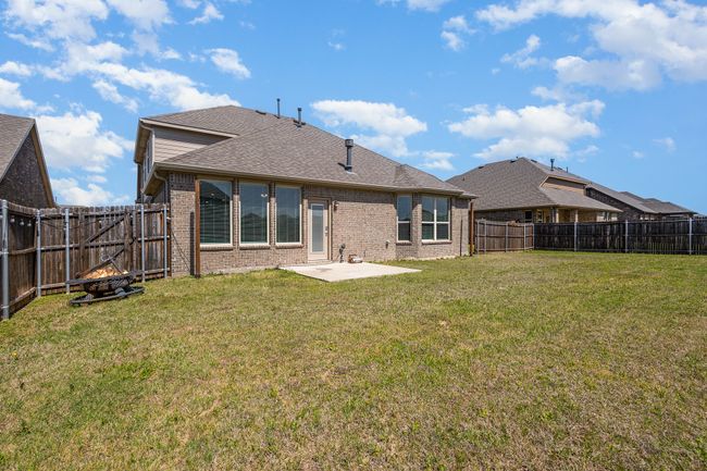 Rear view of property with a patio, brick siding, a fenced backyard, a yard, and a shingled roof | Image 28