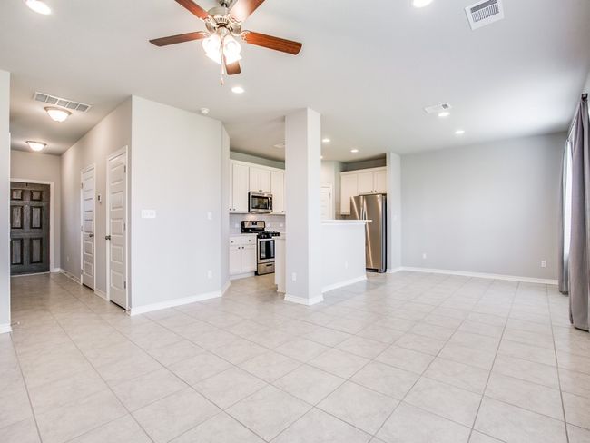 Unfurnished living room with ceiling fan, recessed lighting, light tile patterned floors, and baseboards | Image 6