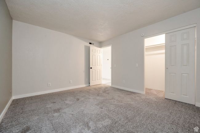 Unfurnished bedroom featuring carpet and a textured ceiling | Image 9
