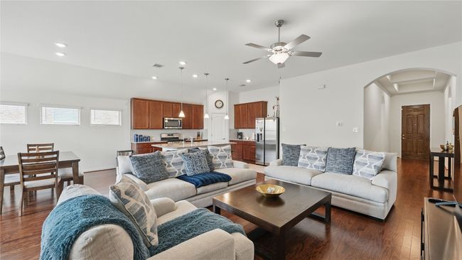 Living room featuring arched walkways, a ceiling fan, dark wood-style floors, and recessed lighting | Image 12