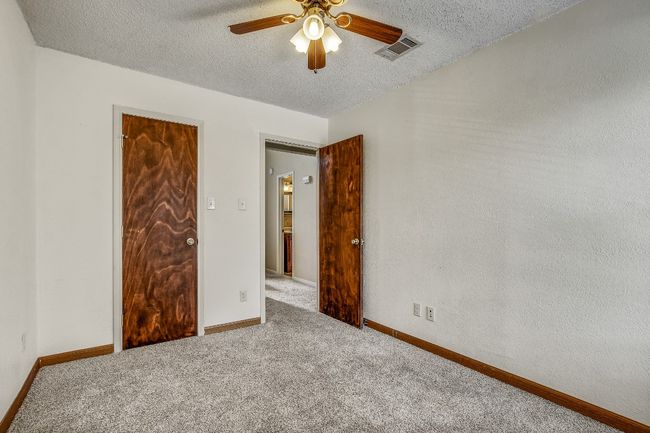 Unfurnished bedroom with carpet floors, a textured ceiling, ceiling fan, and baseboards | Image 13