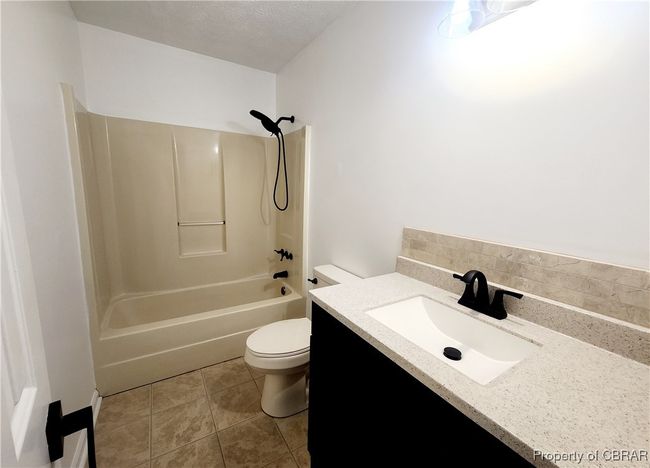 Full bathroom with shower / tub combination, vanity, toilet, and a textured ceiling | Image 13