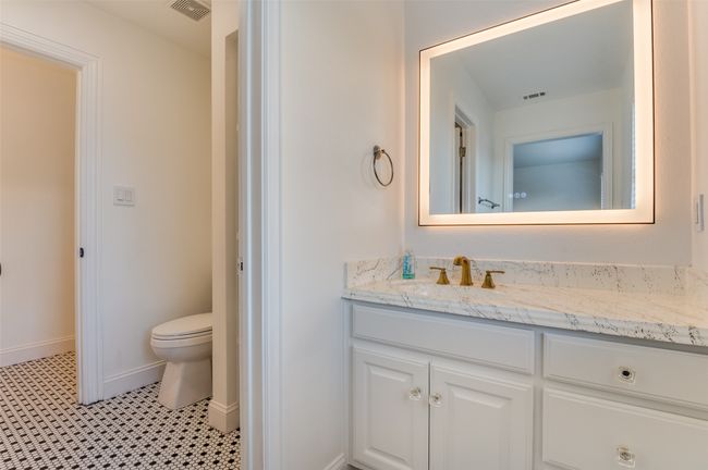 Bathroom featuring baseboards, visible vents, toilet, and vanity | Image 11