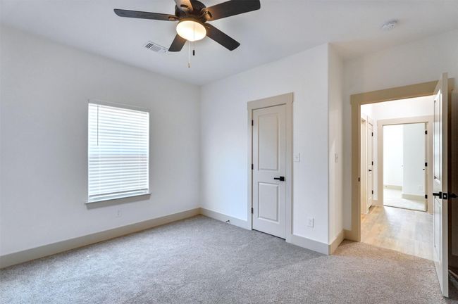 Unfurnished bedroom with visible vents, light colored carpet, baseboards, and ceiling fan | Image 14