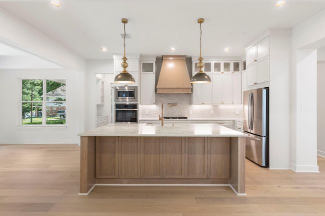 Enjoy casual meals or holiday baking at the huge kitchen island with custom lighting. | Image 7