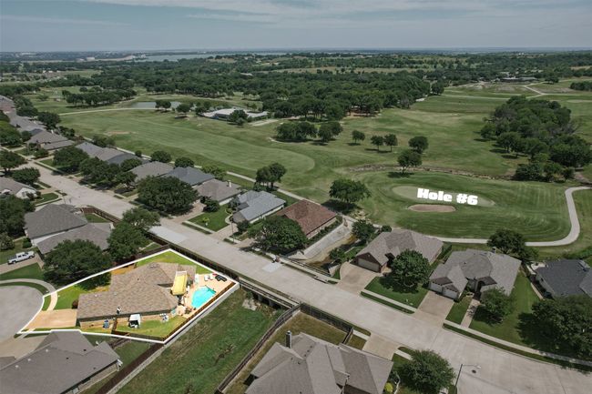 Aerial view of property's location featuring a golf course, property parcel outlined, a large body of water, and nearby suburban area | Image 35