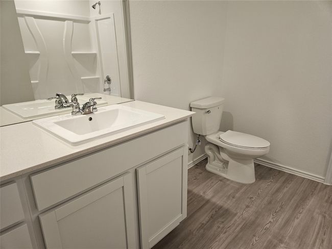 Bathroom featuring toilet, vanity, baseboards, and wood finished floors | Image 8