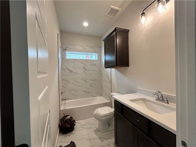 Full bath featuring marble finish flooring, vanity, bathing tub / shower combination, and recessed lighting | Image 13