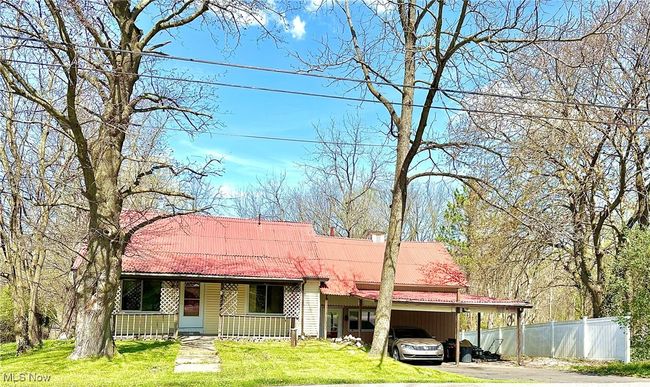 Ranch-style home featuring fence, a porch, an attached carport, and a front yard | Image 44