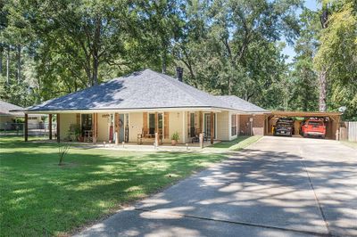 View of front facade with a front lawn, covered porch, and a carport | Image 1