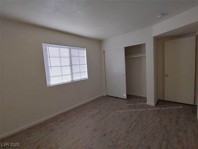 Unfurnished bedroom with wood-type flooring and a closet | Image 8