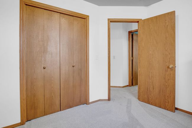 Unfurnished bedroom with light colored carpet, a closet, and baseboards | Image 16