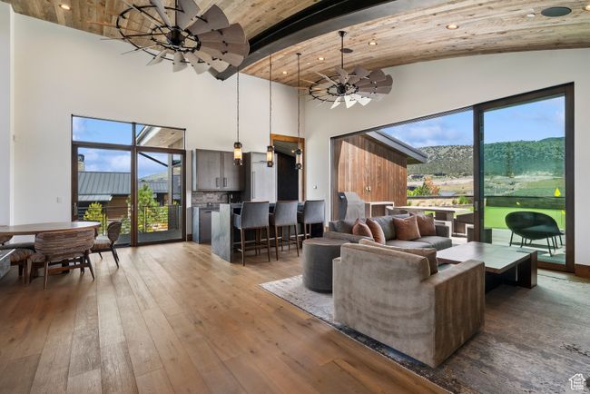 Living area featuring high vaulted ceiling, wood-type flooring, beamed ceiling, and ceiling fan | Image 112