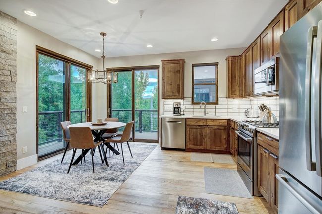 Kitchen featuring an inviting chandelier, stainless steel appliances, plenty of natural light, and a sink | Image 8