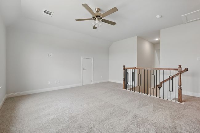 Carpeted spare room featuring visible vents, baseboards, recessed lighting, a ceiling fan, and lofted ceiling | Image 22