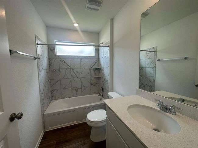 Bathroom with toilet, wood finished floors, shower / bath combination, and vanity | Image 28