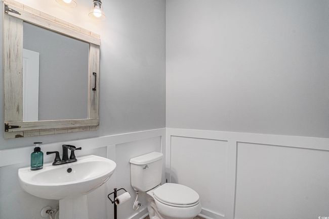 Half bathroom featuring a wainscoted wall and a decorative wall | Image 12