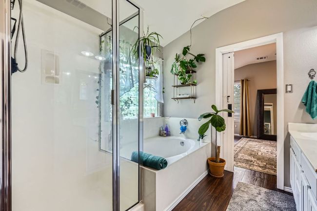 Bathroom featuring a shower stall, vanity, a garden tub, and wood finished floors | Image 14