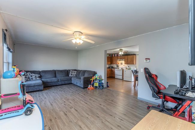 Living room featuring a ceiling fan and light wood-style floors | Image 21