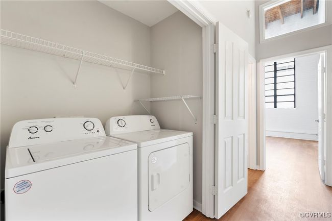 Laundry area with light wood-style flooring, separate washer and dryer, and plenty of natural light | Image 14