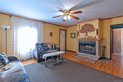 Living room featuring ceiling fan, crown molding, and light wood-type flooring | Image 3