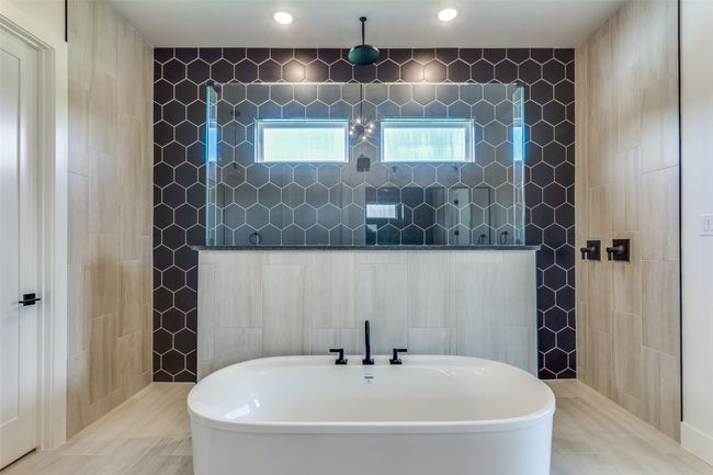 Full bathroom featuring a walk in shower, a freestanding tub, and tile walls | Image 16