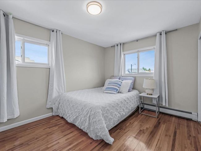 Bedroom featuring wood finished floors, baseboards, and baseboard heating | Image 18