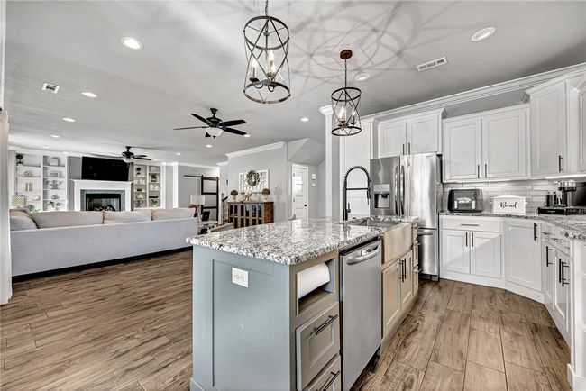 Modern lighting above the island. Notice the paper towel holder beside the dishwasher. | Image 7