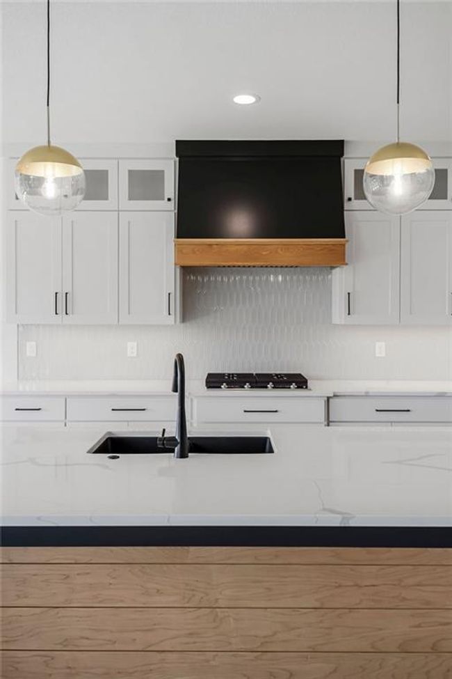 Kitchen featuring white cabinetry, tasteful backsplash, a sink, hanging light fixtures, and recessed lighting | Image 11