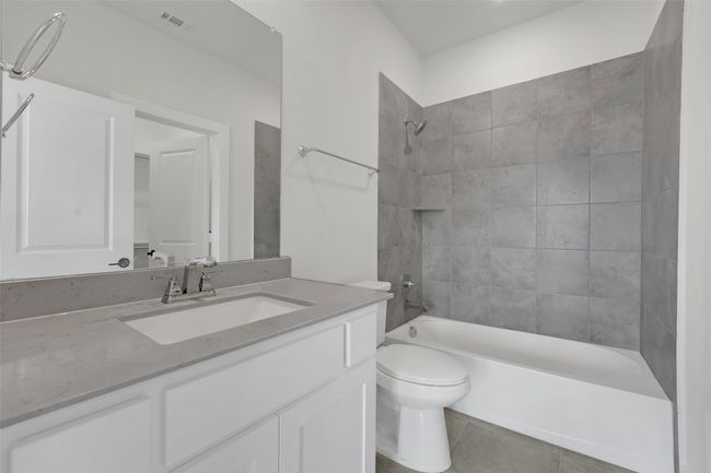 Bathroom featuring vanity, shower / bath combination, toilet, tile patterned flooring, and visible vents | Image 37