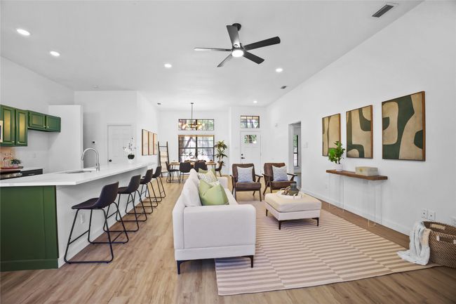 Living room with ceiling fan, light wood-style flooring, recessed lighting, and a chandelier | Image 7
