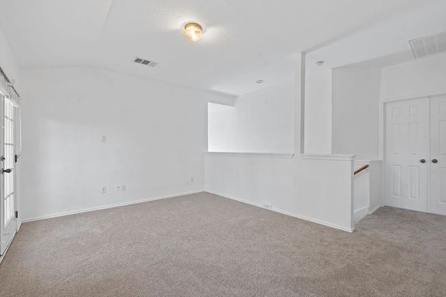 Unfurnished room with carpet, lofted ceiling, and baseboards | Image 13