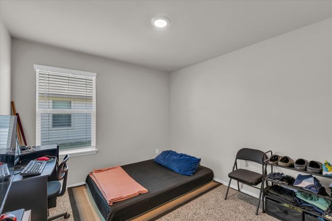 Carpeted bedroom with an office area, baseboards, and multiple windows | Image 23