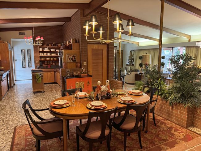 Dining area with a chandelier, brick wall, and beam ceiling | Image 24