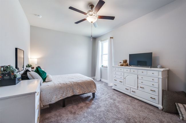 Bedroom with light carpet, baseboards, and ceiling fan | Image 19