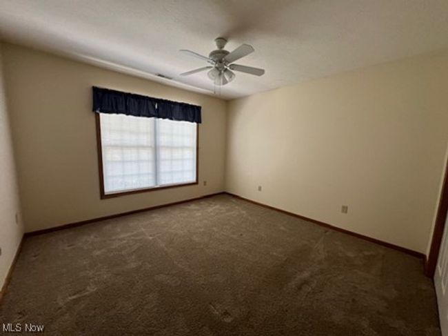 Carpeted spare room featuring a ceiling fan and baseboards | Image 24