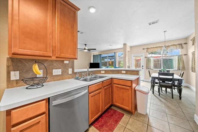 Kitchen featuring stainless steel dishwasher, a sink, a peninsula, tasteful backsplash, and plenty of natural light | Image 25