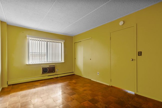 Unfurnished room featuring baseboard heating, a textured ceiling, a wall mounted AC, and a smoke detector | Image 20