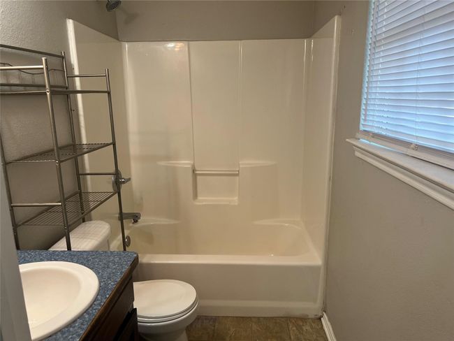 Full bathroom with shower combination, vanity, and a textured wall | Image 15
