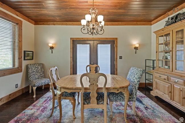 Dining space with wood ceiling, a chandelier, baseboards, french doors, and dark wood-style floors | Image 7
