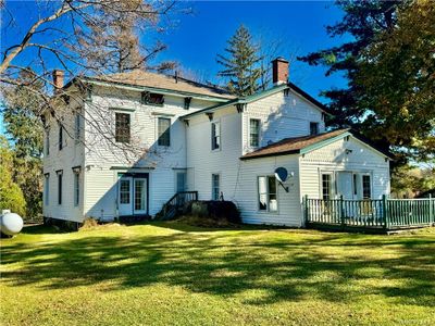 Rear view of house featuring a yard and a wooden deck | Image 1