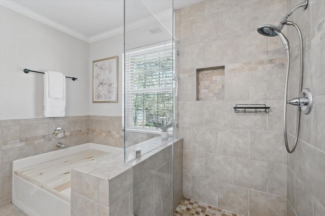 Full bath featuring tiled shower, crown molding, and a bath | Image 21