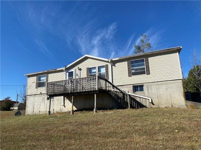 Front of property featuring a wooden deck. | Image 1