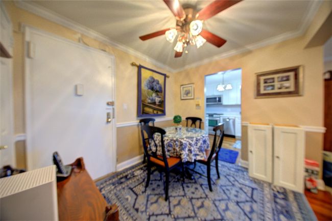 Dining area with wood finished floors, crown molding, and ceiling fan | Image 10