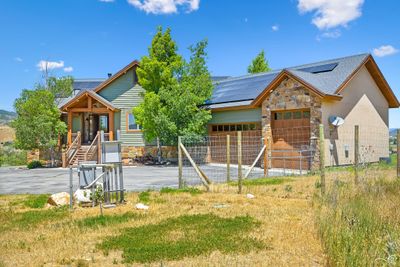 View of front facade featuring a garage and solar panels | Image 3