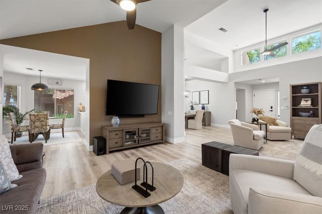 Inside you'll discover soaring majestic ceilings, an open-concept floor plan, sleek pocket windows, & warm natural light. The upgraded interior features luxury flooring, fresh designer paint, & new baseboards. Relax by the linear fireplace or entertain in the formal dining area. | Image 12