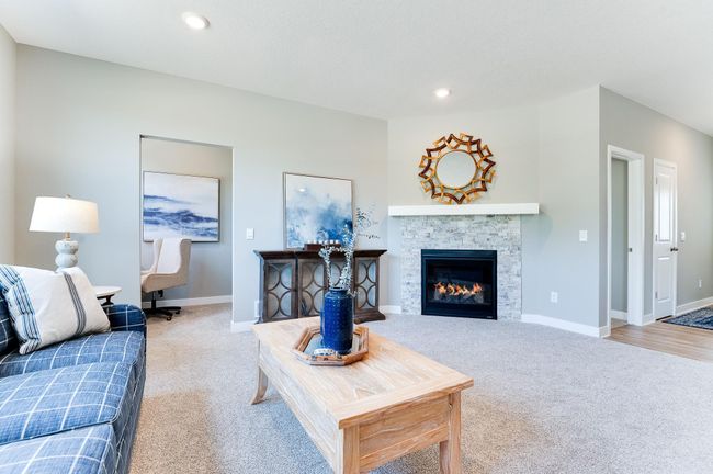 The gas fireplace situated in the corner of the living room provides a warm ambience. Photo of model home, color and options will vary. | Image 10