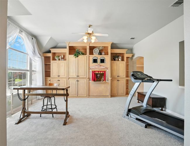 Workout room with ceiling fan, carpet, arched walkways, and lofted ceiling | Image 20