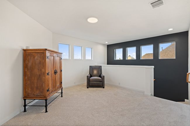 Sitting room featuring baseboards, an upstairs landing, visible vents, and light carpet | Image 16